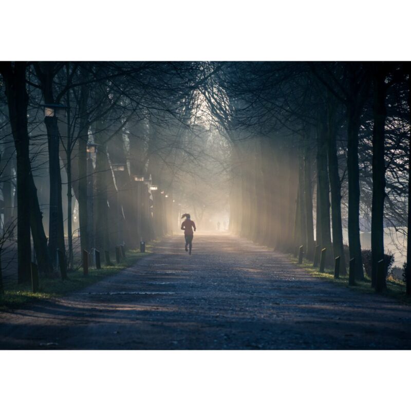 朝陽の中を走っている女性